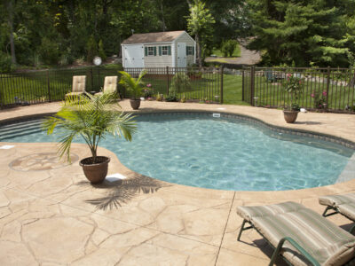 concrete pool deck This is an image of a stamped concrete pool deck on a residential property.